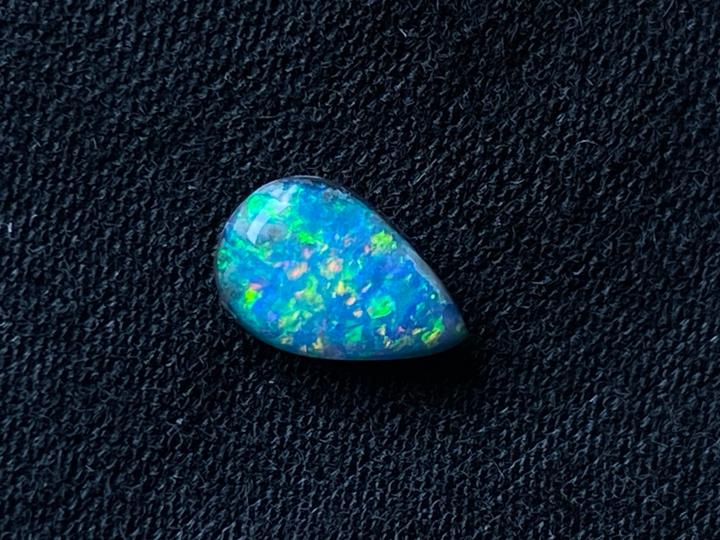 0.72 克拉黑色 Mintabi 泪滴抛光宝石,绚丽的针火彩虹色。